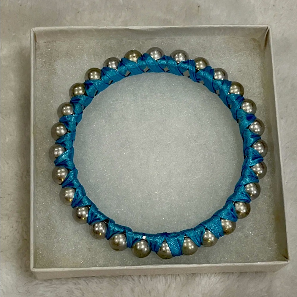 Silver tone bracelet with light blue ribbon